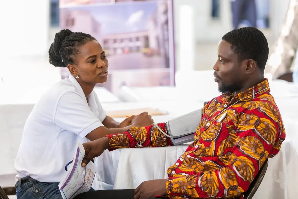 A nurse checks a man’s blood pressure at a health fair in Ghana